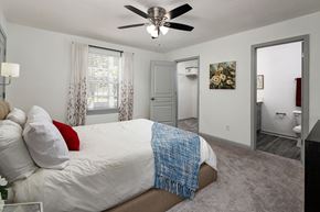 Atlanta apartment for rent - A bedroom with a bed, a ceiling fan, and a door leading to another room.