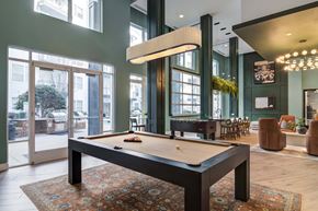 Decatur apartment for rent - A pool table is in the middle of a room with a green wall and a large window.