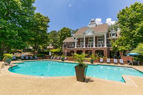Alpharetta apartment for rent - a swimming pool with chairs around it in front of a house