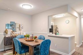 Lorton apartment for rent - A dining room with a wooden table and blue chairs.