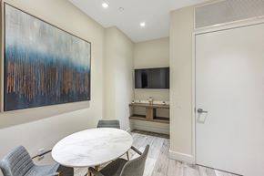 Miami apartment for rent - a dining room with a white table and chairs and a tv in a room