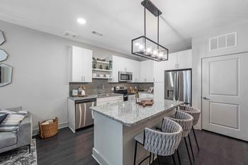 Expansive kitchens with pendant lighting over island bars