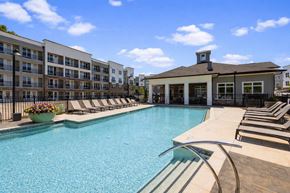 Powder Springs apartment for rent - A large swimming pool with a building in the background.