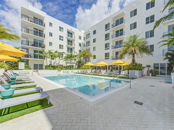 A large swimming pool in front of an apartment building