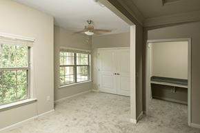 Phenix City apartment for rent - A room with a ceiling fan and a window with a view of trees.