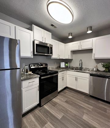 Charlotte apartment for rent - A kitchen with white cabinets and a black stove top.
