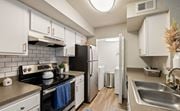 Tallahassee apartment for rent - A kitchen with white cabinets and a black stove top oven.