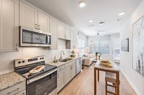 Powder Springs apartment for rent - a kitchen with white cabinets and stainless steel appliances and a dining table