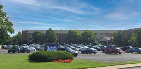 Saginaw apartment for rent - a parking lot with cars and a building in the background