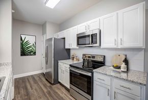 Colorado Springs apartment for rent - A kitchen with white cabinets and a wooden floor.