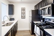 Memphis apartment for rent - an apartment kitchen with black appliances and white counters and a stainless steel refrigerator