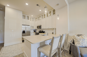 Huntersville apartment for rent - A kitchen with white cabinets and a large island with chairs around it.