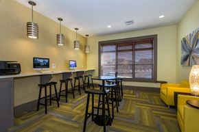 Colorado Springs apartment for rent - a lounge area with a bar and chairs and a television