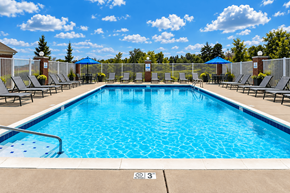 Cold Spring apartment for rent - A large outdoor swimming pool surrounded by lounge chairs and umbrellas.