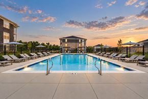Lebanon apartment for rent - A large swimming pool surrounded by lounge chairs and umbrellas.