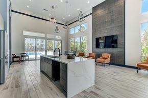 Jacksonville apartment for rent - A modern kitchen with a large island and a refrigerator on the left.