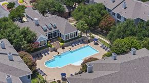 Austin apartment for rent - A swimming pool surrounded by a small building and trees.