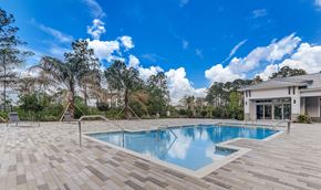 Jacksonville apartment for rent - A swimming pool surrounded by a wooden deck and trees.
