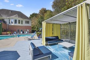 Decatur apartment for rent - a pool with lounge chairs and umbrellas and a house in the background