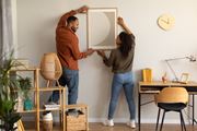Plantation apartment for rent - a man and a woman are hanging a mirror on a wall