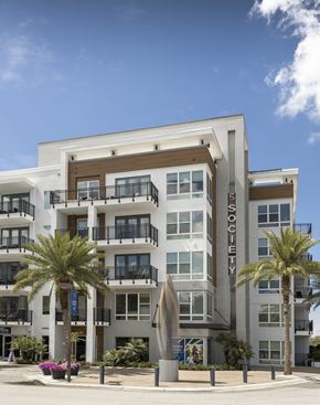 Tampa apartment for rent - A modern apartment building named "Society" with balconies and palm trees in front.