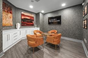 Tampa apartment for rent - Two orange chairs are placed in front of a wall with a Society Westshore sign.
