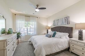 Easley apartment for rent - A bedroom with a large bed, a dresser, and a ceiling fan.
