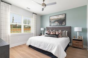 Johnson City apartment for rent - A bedroom with a large bed and a ceiling fan.