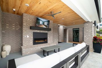 Two outdoor gathering spaces with gas grills, firepits, seating areas and large screen televisions