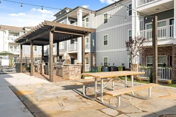 Outdoor biergarten styled with decorative lighting, plenty of seating and covered grilling stations