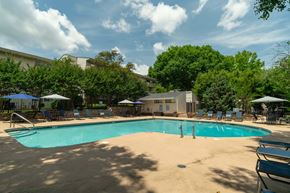 Knoxville townhouse for rent - A large swimming pool surrounded by trees and a building in the background.