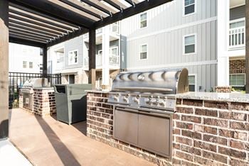 Outdoor biergarten styled with decorative lighting, plenty of seating and covered grilling stations