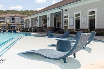 Sundeck with lounge chairs, tables with chairs, and four cabanas