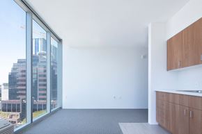 Honolulu condo for rent - an empty room with a large window and a kitchen