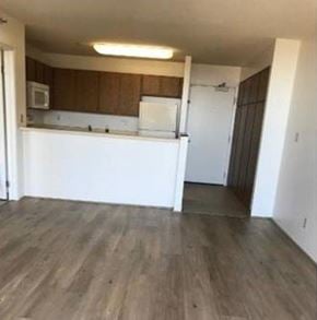 Aiea apartment for rent - A kitchen with white appliances and wooden cabinets.