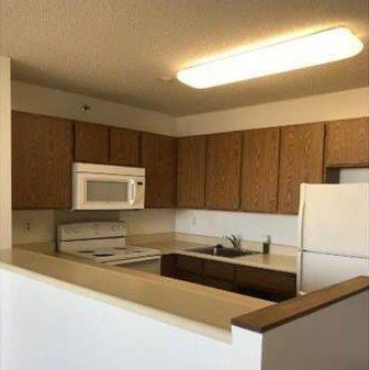 Aiea apartment for rent - A kitchen with brown cabinets and white appliances.