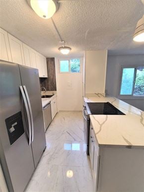 Honolulu condo for rent - A kitchen with a refrigerator, countertops, and cabinets.