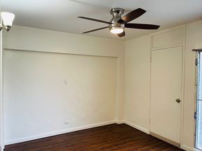 Honolulu apartment for rent - A room with a ceiling fan and wooden floors.