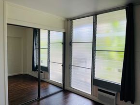 Honolulu apartment for rent - A room with a sliding glass door and a black curtain.