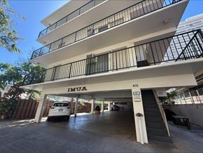 Honolulu apartment for rent - A white car is parked in the garage of a multi-story building.