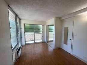 Honolulu apartment for rent - A room with wooden floors and white walls.