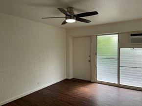 Honolulu apartment for rent - A room with a ceiling fan and sliding glass doors.