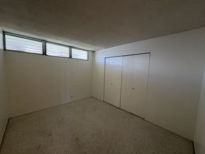Honolulu condo for rent - A room with a carpeted floor and two white doors.