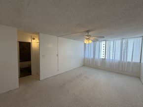 Honolulu condo for rent - A room with a ceiling fan and a window with curtains.