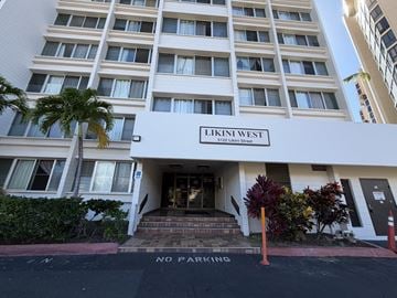 Honolulu condo for rent - The front of a white building with the name Likini West on it.