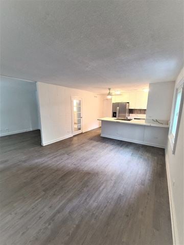 Honolulu condo for rent - A kitchen area with a refrigerator, microwave, and oven.