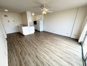 Honolulu apartment for rent - A room with a ceiling fan and wooden flooring.