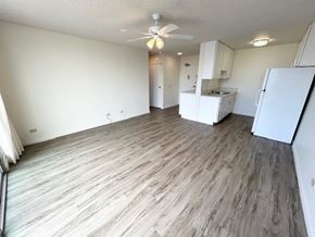 Honolulu apartment for rent - A kitchen area with a refrigerator, sink, and cabinets.