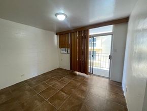 Honolulu apartment for rent - A room with brown tiled flooring and a sliding glass door.