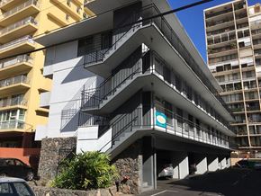 Honolulu apartment for rent - a building with three balconies and a parking lot